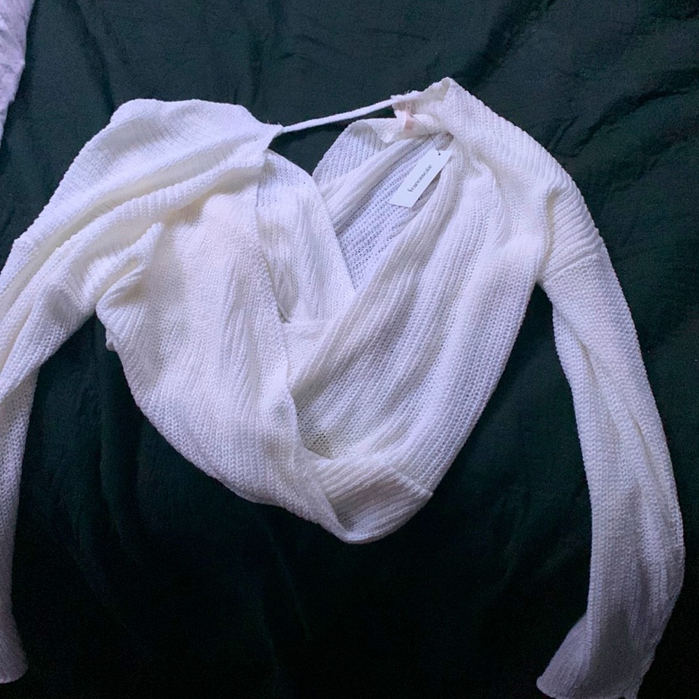 This is a new, never been worn, crossed white sweater. Tag on it!